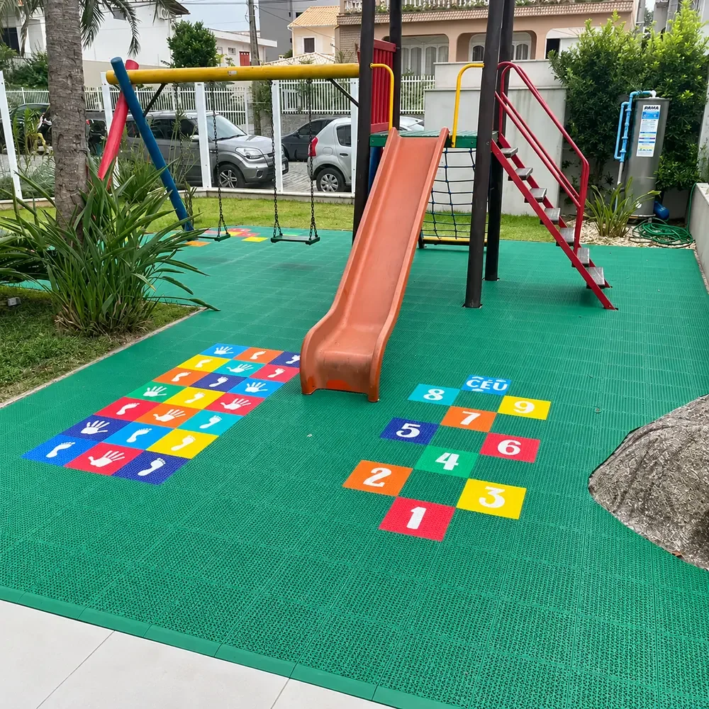 Parquinho sobre piso verde com amarelinhas coloridas